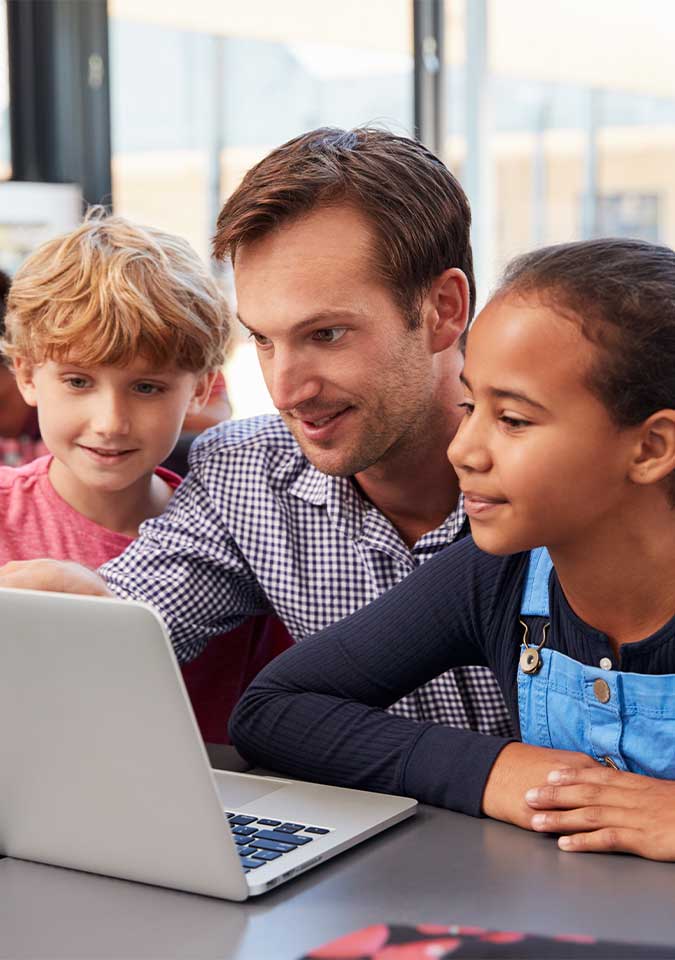 teacher and students looking at computer