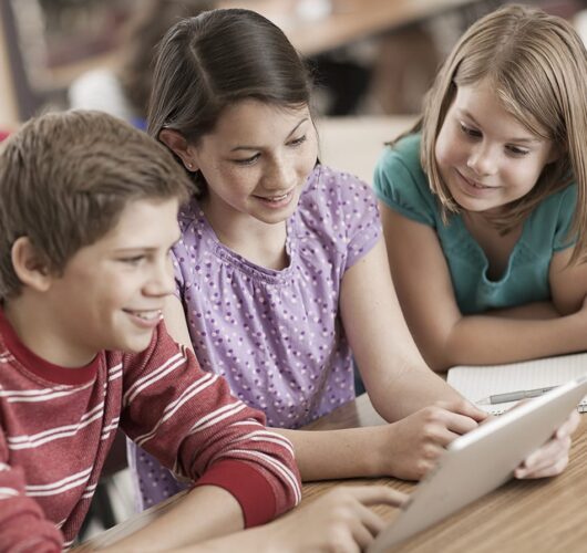 young students looking at tablet