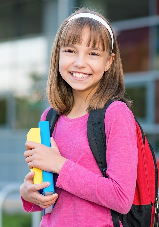 young student smiling with books